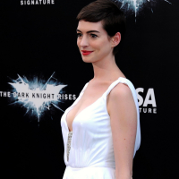 Anne Hathaway showing cleavage in white dress at Dark Knight Rises premiere in