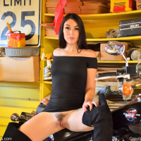 Ashley Wolf poses in a tight dress on a motorcycle