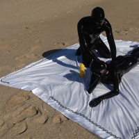 Kinky Latex Lara gets talked into jerking off a dick on the beach