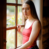 Beautiful girl Izzy Lush gets naked while posing by the window