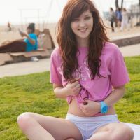Redhead coed Ellena Woods invites you to have some fun with her on the beach