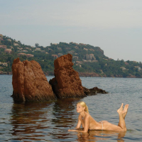 Seductive blonde Adriana Malkova poses on the beach