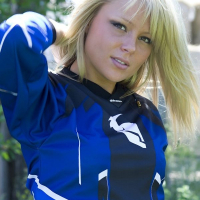Beautiful blonde Madden in blue posing on a motorcycle