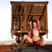 Tattooed babe Skin Diamond poses in her boots outdoor at the train